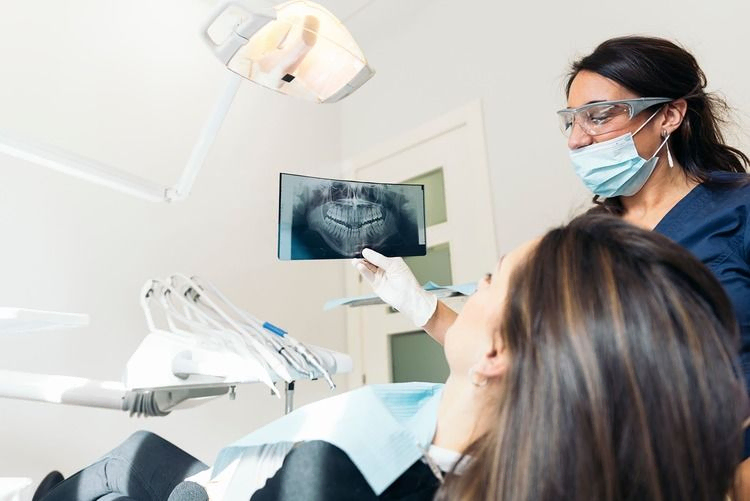 dentista mostrando radiografía a cliente
